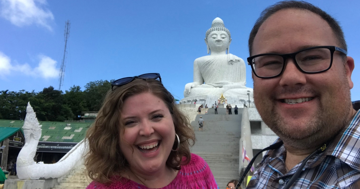 Jimmy and Amanda of Chubby and Away smiling in front of a statue