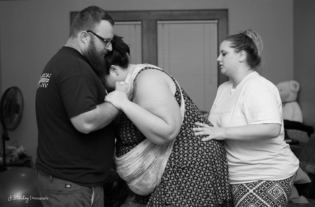 Man and woman helping Courtney with her home birth