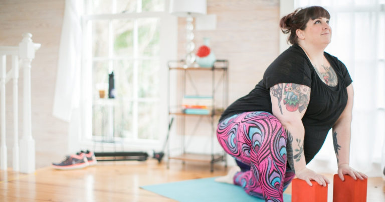 plus size woman doing yoga in her apartment