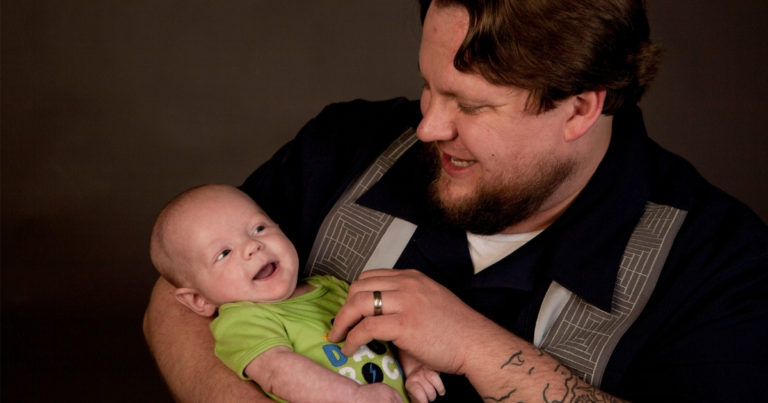 plus size dad holding baby