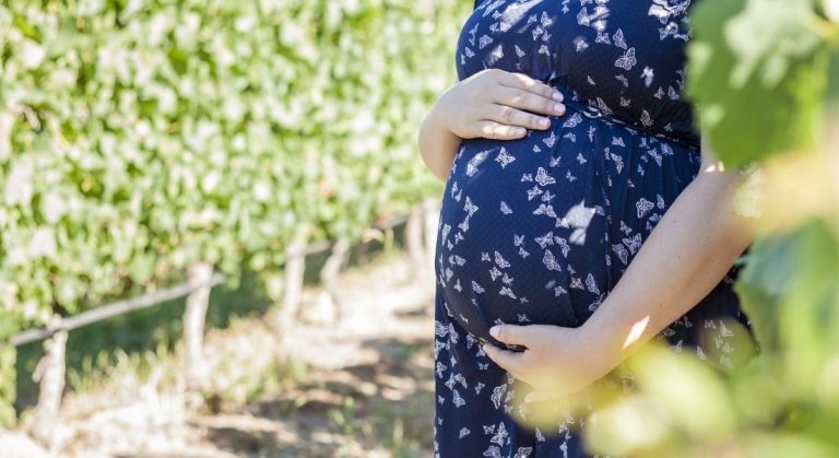 plus size pregnant woman holding her belly