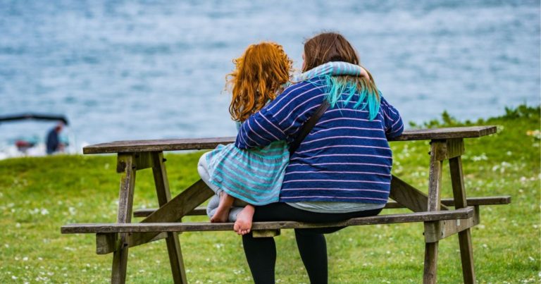 plus size mother with daughter sitting on a bench