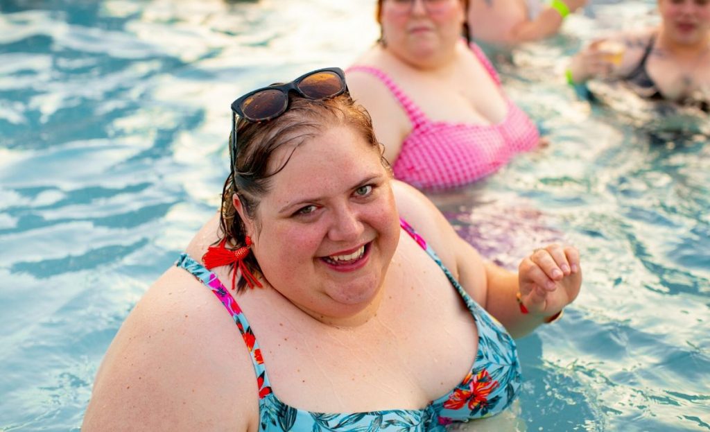 plus size woman in pool smiling 