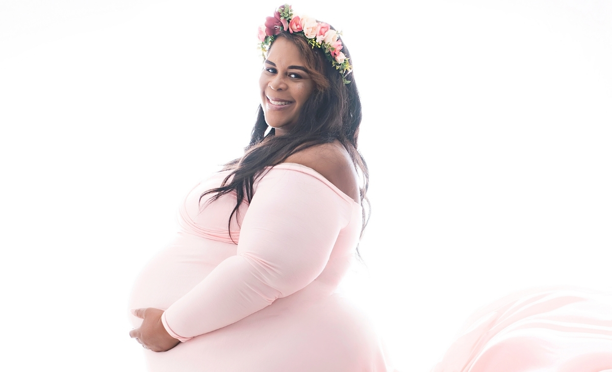 plus size pregnant woman wearing a pink gown