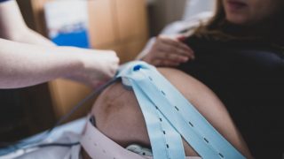 size-friendly doula helping with monitoring straps during labor