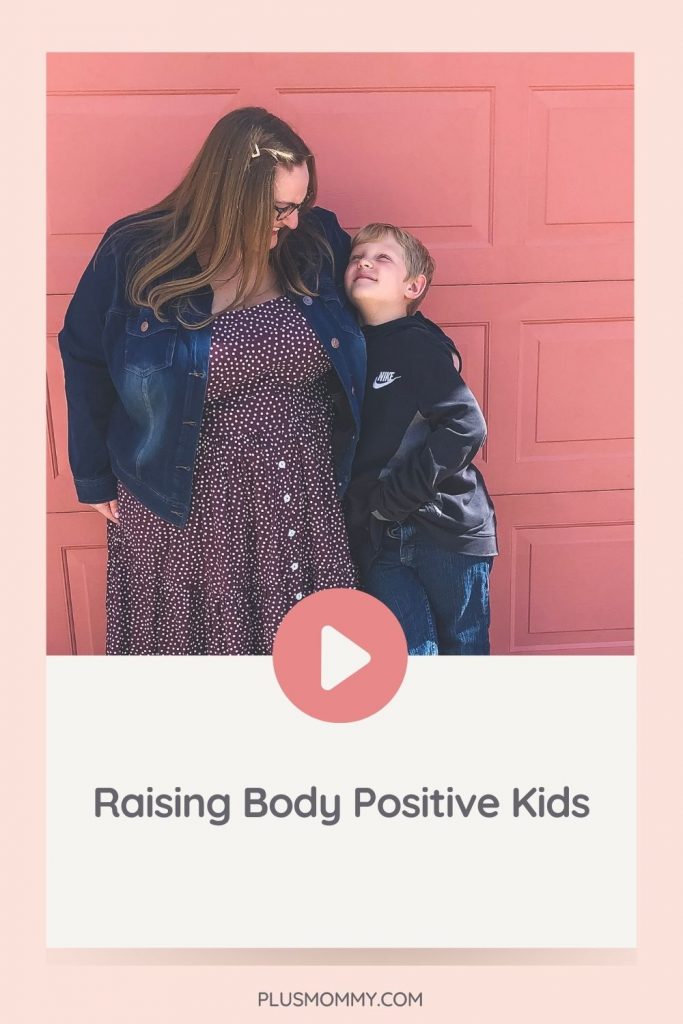 plus size mother and her son standing with a pink wall behind them. 