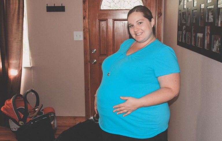 plus size pregnant woman holding belly