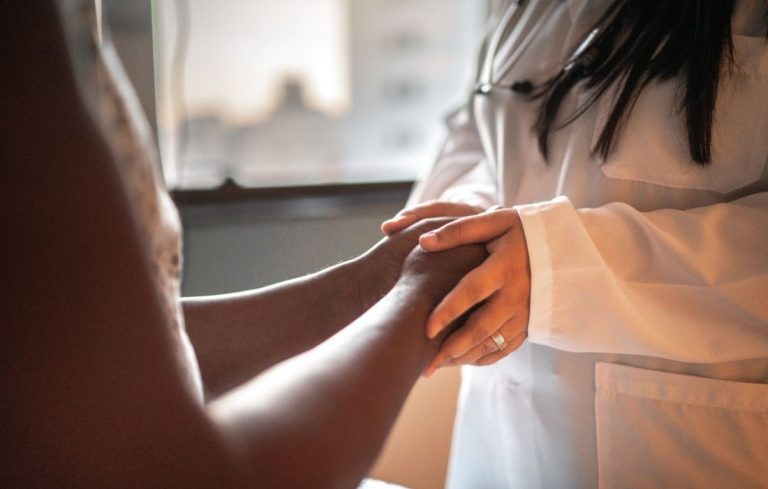 plus size woman at doctors office holding hands with doctor