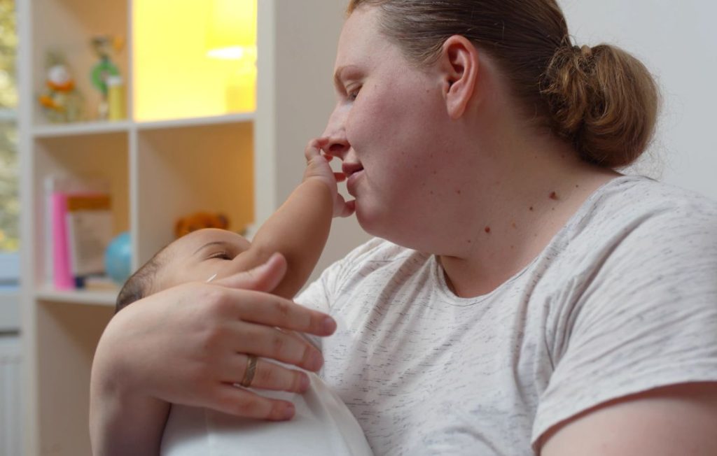 Plus Size Pregnancy UK woman holding baby 