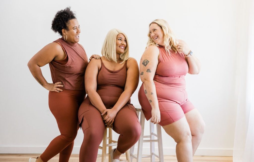 plus size women showing wellness in a body-positive way wearing workout clothes 