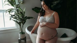 photo of a plus size woman holding her belly celebrating a Donor Egg Success Story