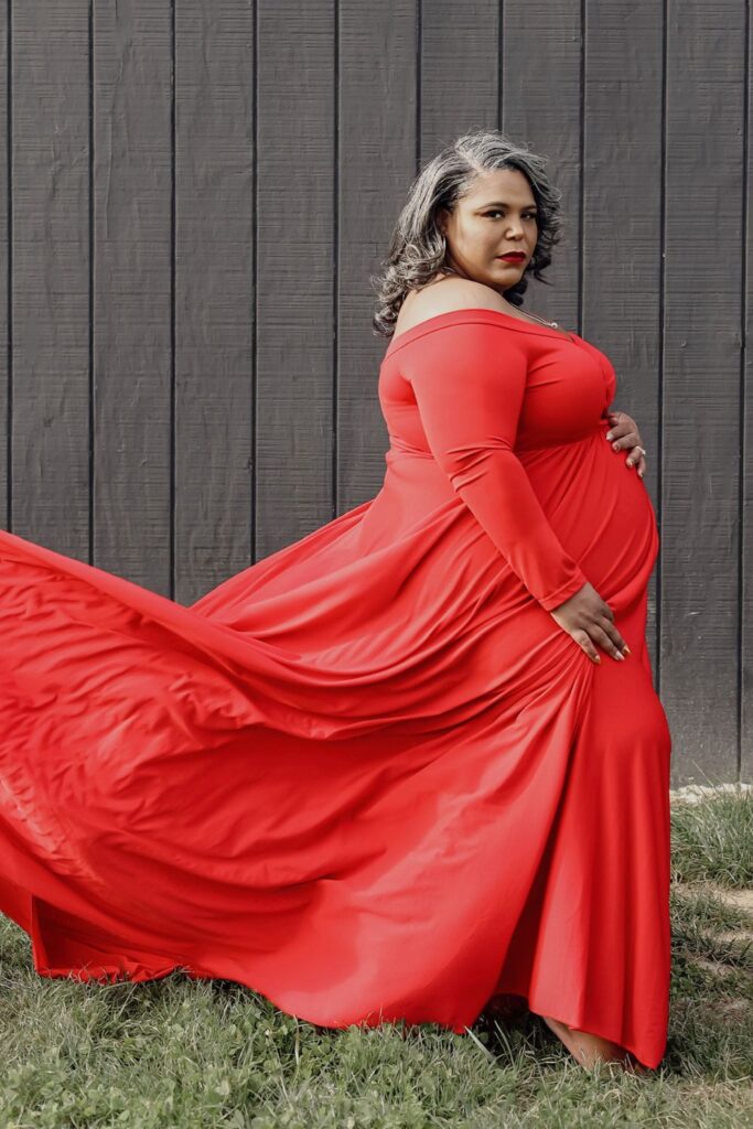 Plus Size Pregnant woman in a red plus size maternity dress