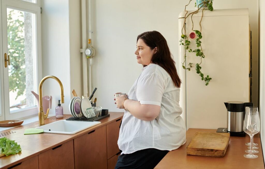 fat and pregnant woman holding a mug